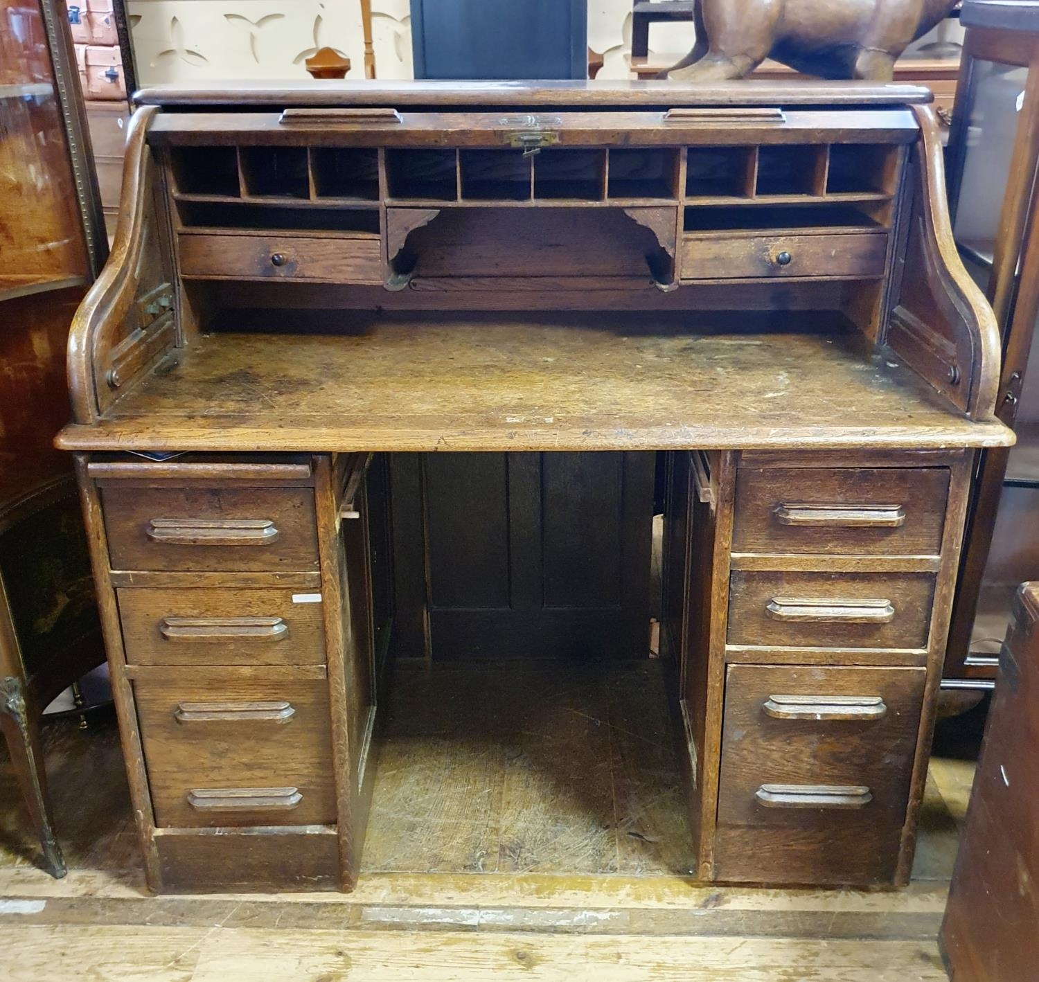 An oak tambour front desk, 128 cm wide, in need of extensive restoration, a mahogany display