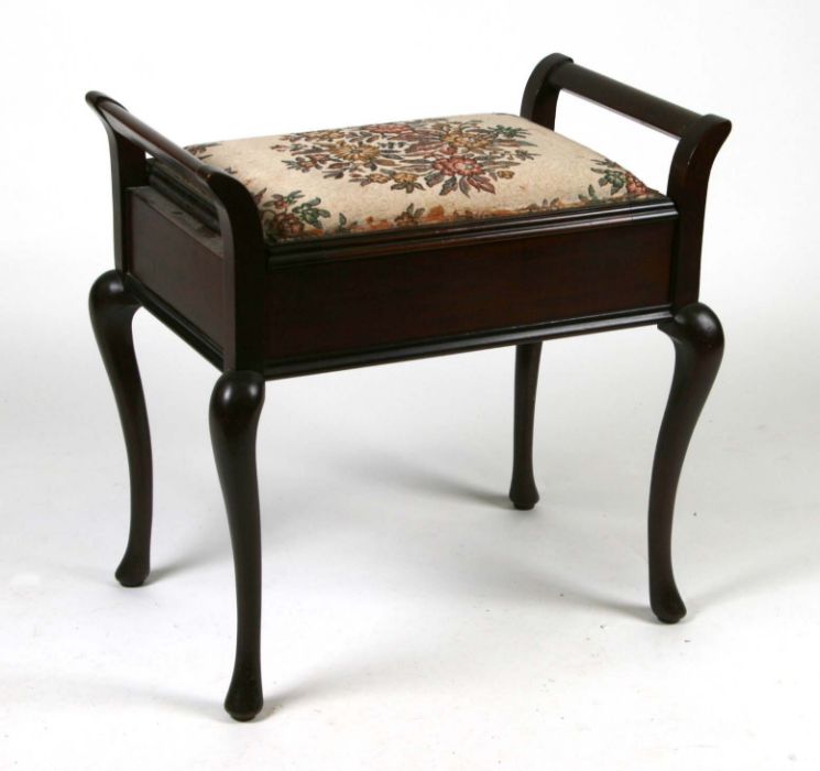 An Edwardian mahogany piano stool with upholstered lift-up seat.