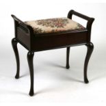 An Edwardian mahogany piano stool with upholstered lift-up seat.