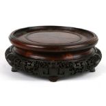 A large Chinese carved hardwood vase stand with pierced decoration, 27cms diameter.Condition