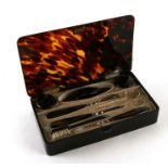 An Edwardian tortoiseshell manicure set with fitted interior and silver hinges, London 1904, 20cms