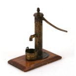 A late Victorian / Edwardian novelty desk top accessory in the form of a brass water pump and pail