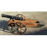 A 19th century cast iron cannon mounted on a later wood and metal carriage. The barrel with GR
