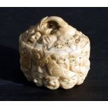 A Chinese carved ivory box and cover, the surface profusely carved with images of faces, 5cms wide.
