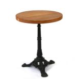 A cast iron pub table with later circular solid oak top, 55cms diameter.