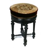 A Victorian Aesthetic period revolving piano stool on an ebonised base, 39cms diameter.