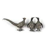 A silver and enamel paste set brooch in the form of two penguins, 2.5cms high; together with a