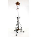 A late 19th century wrought iron and copper standard lamp.