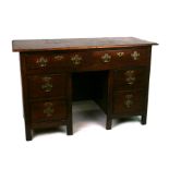 An oak kneehole desk with an arrangement of six drawers, 126cms wide (adapted from an 18th century