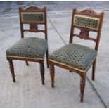 A pair of Victorian walnut hall chairs with padded back splats and overstuffed seats, on turned