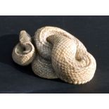 A Chinese carved ivory figure in the form of a coiled snake, 4.5cms wide.Condition ReportSome