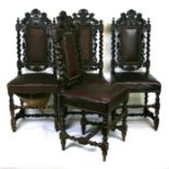 A set of four 17th century style carved oak dining chairs with heavily carved back splats flanked by