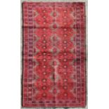 A Persian Balouch woollen rug with stylised guls within multi borders, 205 by 125cms (433).