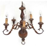 A continental turned wood and cast five-arm ceiling light, 56cms high.