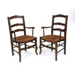 A pair of country ladderback elm and beech elbow chairs (2).