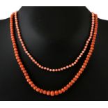 A group of three coral bead necklaces.
