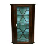 A 19th century mahogany corner cupboard with astragal glazed door enclosing a shelved interior,
