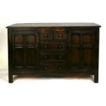 A Maple stained elm dresser base with an arrangement of five drawers and two panelled doors, on