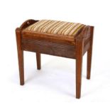 An oak piano stool with upholstered lift-up seat, 58cms wide.