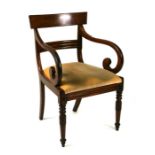 A William IV mahogany elbow chair with overstuffed seat and carved acanthus leaf tapering front