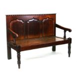 An 18th / 19th century country house hall bench with a three arched panel back, solid seat, on