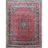 A Persian woollen hand knotted Kashan carpet, the elongated central medallion within floral borders,