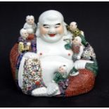 A Chinese Republic style famille rose figure of Buddha seated with his young attendants, oval