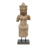 A Khmer carved sandstone standing female figure mounted on a later stand, old damages and losses,