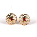 A pair of 9ct gold pierced stud earrings in a Celtic design, set with square garnets.