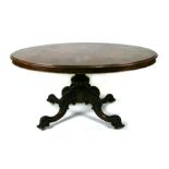 A Victorian burr walnut oval snap or tilt-top breakfast table on turned column and carved quatrefoil