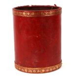 A red leather waste paper bin with gilt decorated borders, of cylindrical form, 25cms diameter.