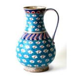 An Iznik pottery water jug decorated with stylised clouds on a turquoise ground, 25cms high.