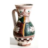 A Mediterranean tin glazed pottery jug decorated with flowers, 20cms high.