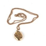 A 9ct gold locket with foliate engraved decoration suspended on a 9ct gold rope twist chain, 13.8g.