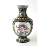 A large Chinese Canton enamel vase decorated with a phoenix and flowers within panels with scrolling