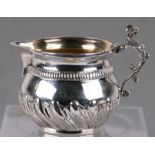 A silver cream jug with stylised dragon handle and gilded interior, London 1892, 6cms high, 91g.