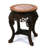 A Chinese carved hardwood plant or bowl stand with inset rouge marble top with foliate carved