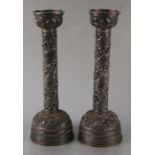 A pair of pierced Nepalese white metal pricket candlesticks decorated with foliate scrolls and