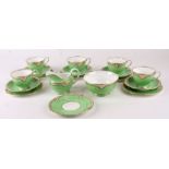 An Ainsley part tea set with a green ground and gilt highlights.