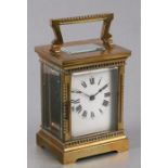 A French brass cased carriage clock with ornate dentil cornice, presentation description to the