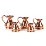 A group of graduated 19th century copper harvest jugs with lead seals, half pint, 1 gill, half gill,
