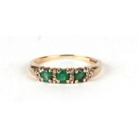 A 9ct gold half hoop ring set with three green stones interspersed with diamonds, approx UK size '