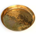 A large hammered brass tray, 62cms diameter.