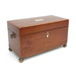 An early 19th century mahogany three-division tea caddy on brass ball feet, 31cms wide.