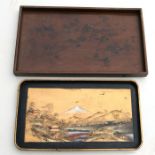 A Japanese black lacquer and gilt tray decorated with a mountainous landscape scene, 60cms wide;