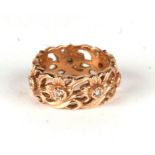 An ornate 14ct gold eternity ring with cast and pierced foliate design set with seven diamonds,