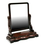 A Victorian figured mahogany toilet mirror, 64cms wide.