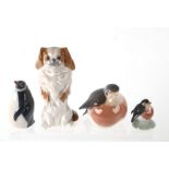 A Royal Copenhagen Pekinese figure, 12cms high; together with three Royal Copenhagen penguin figures