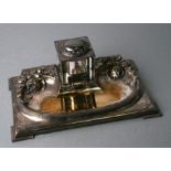 A continental Arts & Crafts silver plated desk stand with central glass inkwell, 27cms wide.