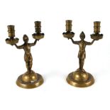 A pair of brass figural twin-arm candlesticks.